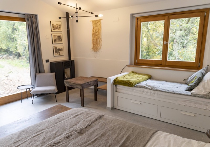 Bedroom area with double bed, daybed and wood-burning stove