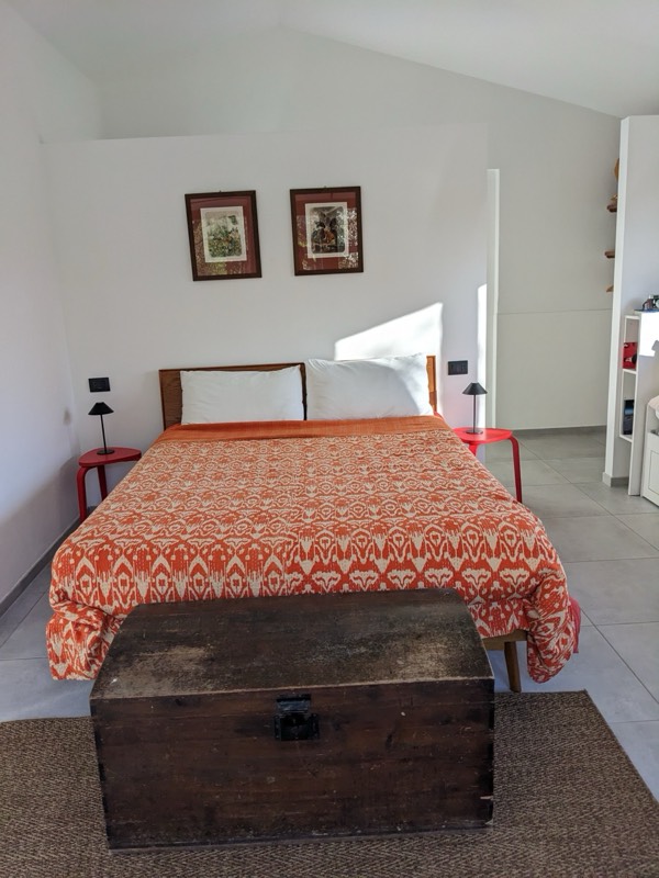 Bedroom with vibrant ikat bedspread and botanical prints